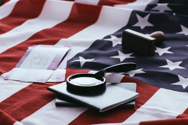 Foyer sélectif des passeports et loupe près des billets et du drapeau américain — Photo de stock
