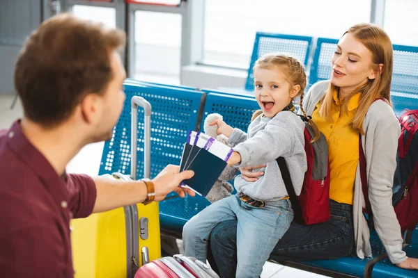 Вибірковий фокус схвильований дочка посміхається з матір'ю поблизу батько з паспортів з авіаквитків — стокове фото