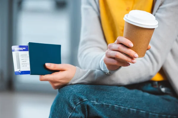 Vista recortada de la mujer sosteniendo taza desechable en el aeropuerto - foto de stock