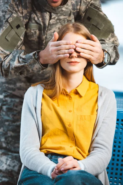 Cropped view of veteran closing eyes of girlfriend — Stock Photo