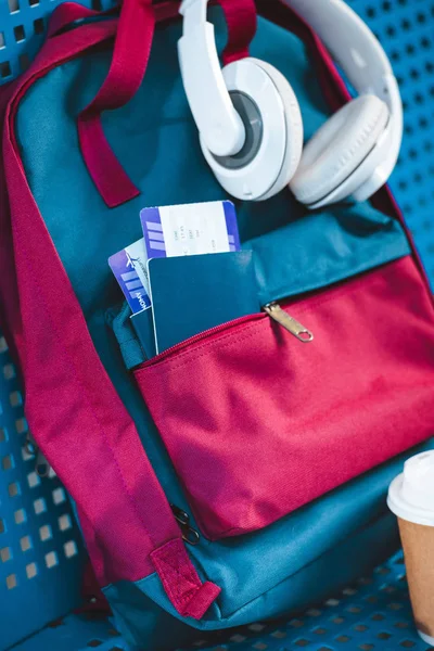Auriculares en la mochila con pasaportes y billetes de avión en el bolsillo - foto de stock