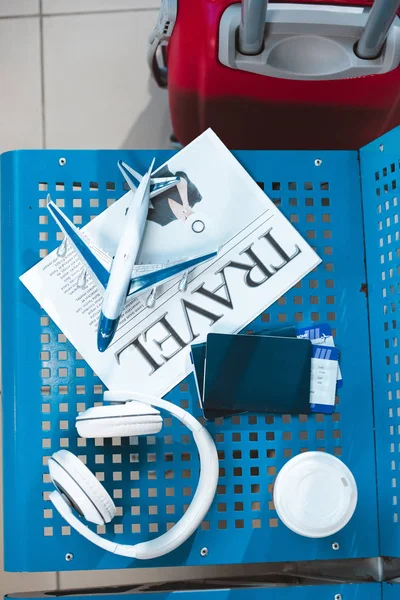 Vue du dessus du modèle d'avion sur le journal de voyage près de tasse en papier et écouteurs — Photo de stock