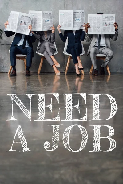 Businesspeople sitting on chairs and holding newspapers in front of faces in waiting hall with need a job lettering on floor — Stock Photo