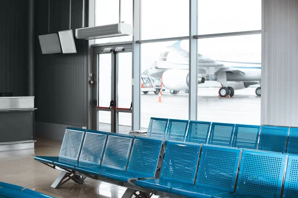 Пустой зал ожидания с синими металлическими креслами в аэропорту — стоковое фото