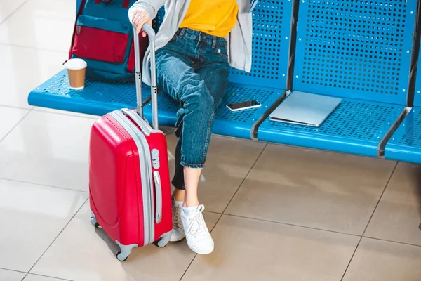 Vue recadrée de la femme avec des bagages près du sac à dos ordinateur portable et smartphone — Photo de stock