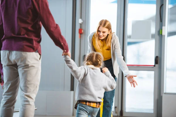 Selective focus of cheerful mother smiling to daughter in airport — Stock Photo