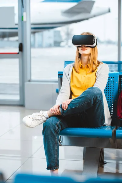 Женщина в гарнитуре виртуальной реальности во время ожидания в аэропорту — стоковое фото