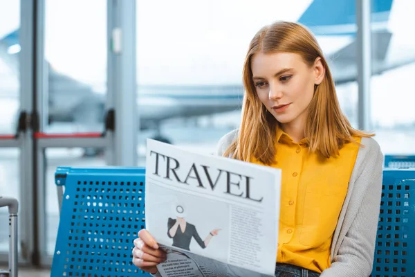 Bella donna che legge giornale di viaggio nella sala partenze — Foto stock