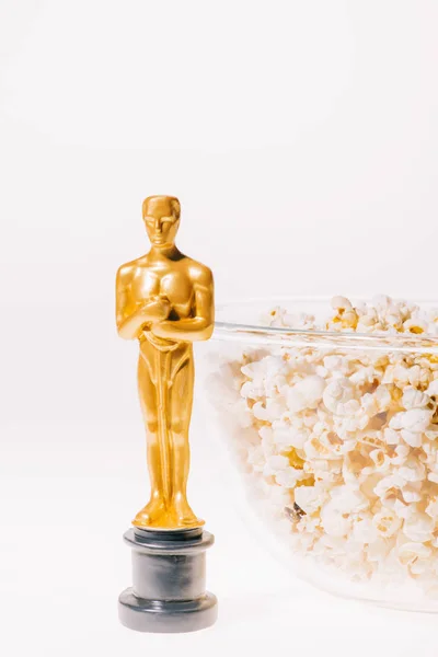KYIV, UKRAINE - JANUARY 10, 2019: shiny oscar award with popcorn bowl isolated on white — Stock Photo