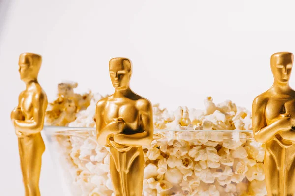 KYIV, UCRANIA - 10 DE ENERO DE 2019: Oscar premia estatuillas con tazón de palomitas de maíz aisladas en blanco - foto de stock