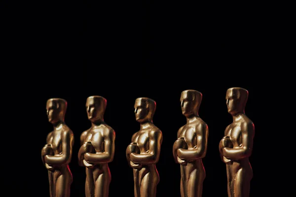 KYIV, UCRANIA - 10 DE ENERO DE 2019: fila de estatuillas de premios Oscar de Hollywood aisladas en negro - foto de stock