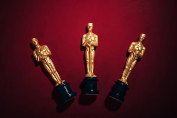 KYIV, UCRANIA - 10 DE ENERO DE 2019: vista superior de las estatuillas de los premios Óscar dorados sobre fondo rojo - foto de stock