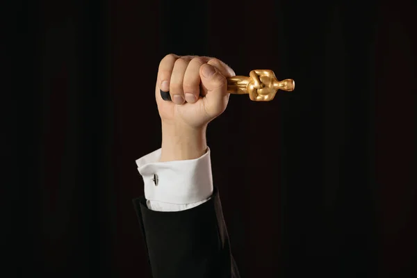 KYIV, UCRANIA - 10 DE ENERO DE 2019: vista recortada del hombre que sostiene el premio Oscar aislado en negro - foto de stock