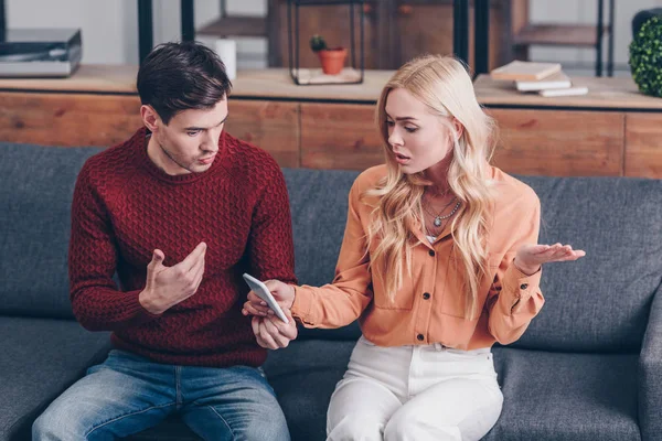 Vue grand angle de jeunes couples se quereller sur smartphone à la maison, concept de méfiance — Photo de stock