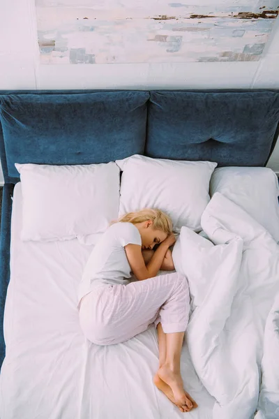Вид сверху стрессовой женщины, лежащей в постели дома — стоковое фото