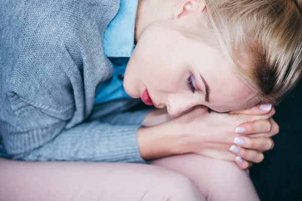 Close up of sad woman with folded hands sitting at home — Stock Photo