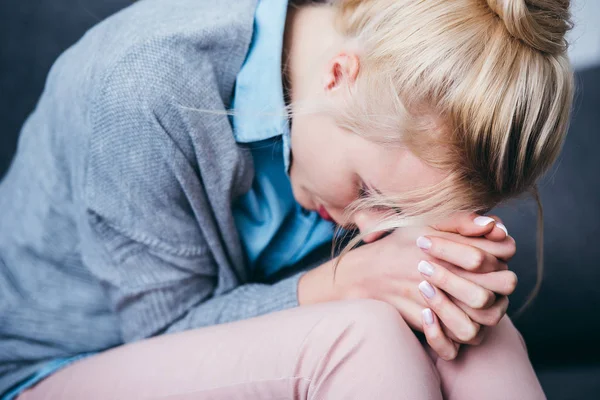 Nahaufnahme einer traurigen Frau mit gefalteten Händen, die zu Hause sitzt — Stockfoto