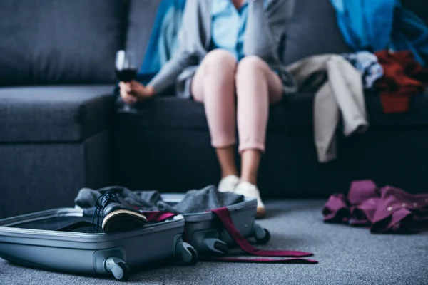Cropped view of woman sitting with glass of red wine while packing in living room after breaking up with boyfriend — Stock Photo