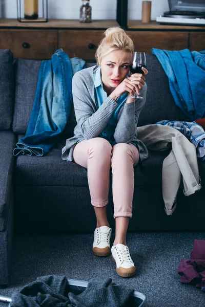 Depressed woman sitting with glass of red wine while packing in living room after breaking up with boyfriend — Stock Photo