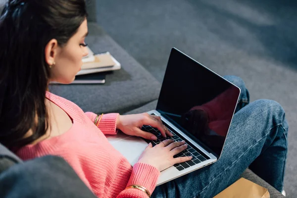 Mulher indiana estudando no laptop com tela em branco no sofá com livros — Fotografia de Stock