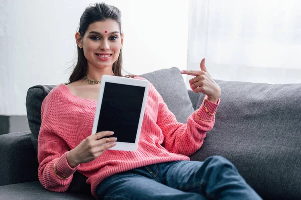 Felice donna indiana con bindi puntando al tablet digitale con schermo bianco — Foto stock