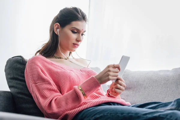 Belle femme indienne avec bindi écouter de la musique avec écouteurs et smartphone — Photo de stock