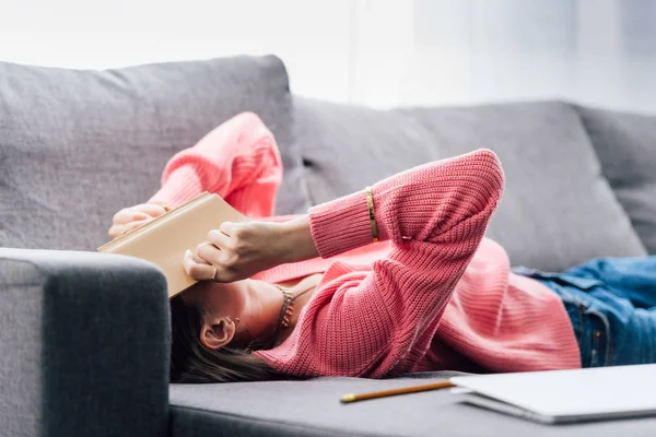 Épuisé étudiant indien couché sur canapé avec livre — Photo de stock