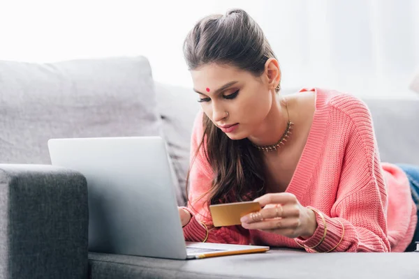 Mulher indiana atraente com bindi compras on-line com laptop e cartão de crédito — Fotografia de Stock