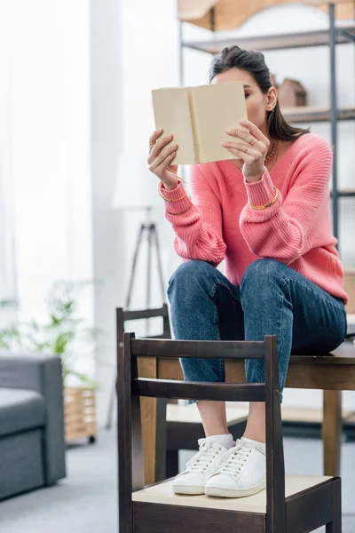 Studentessa con libro di lettura bindi a casa — Foto stock