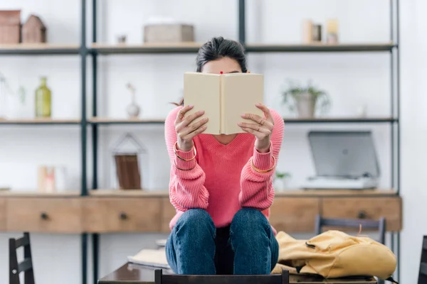 Estudiante indio con libro de lectura bindi en casa - foto de stock