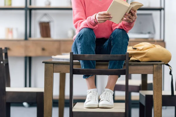 Vista ritagliata di studentessa che studia con libro a casa — Foto stock