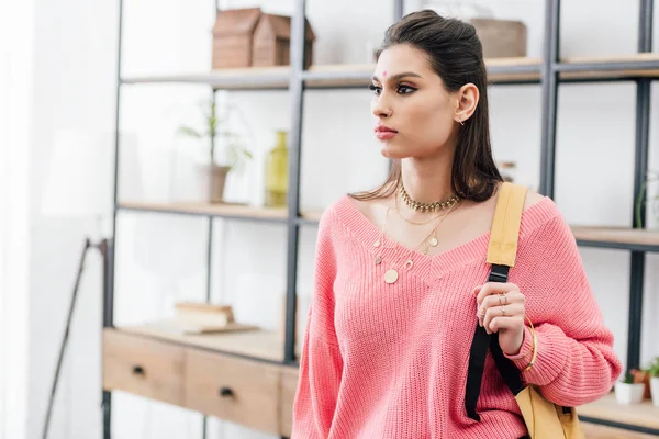 Attractive indian woman in pink clothes with backpack at home — Stock Photo