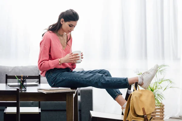 Attractive indian student holding cup of coffee at home — Stock Photo