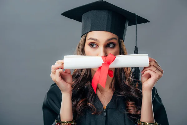 Индийская студентка в выпускной шляпе с дипломом, изолированная от серых — стоковое фото