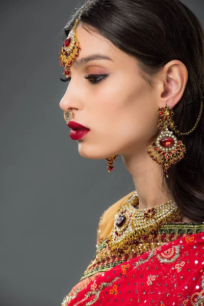 Schöne indische Frau posiert in traditioneller Kleidung und Bindi, isoliert auf grau — Stockfoto