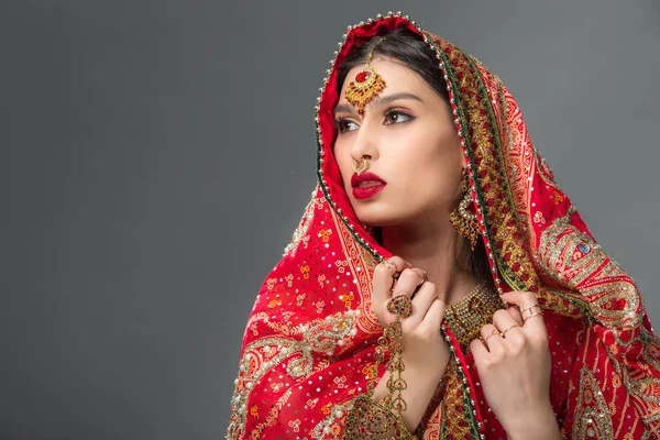 Приваблива жінка позує в традиційному індійському одязі, ізольована на сірому — стокове фото