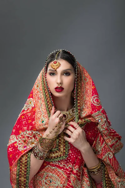 Hermosa mujer india posando en sari tradicional, aislado en gris - foto de stock