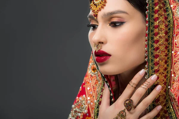 Atractiva mujer india posando en sari tradicional, aislada en gris - foto de stock