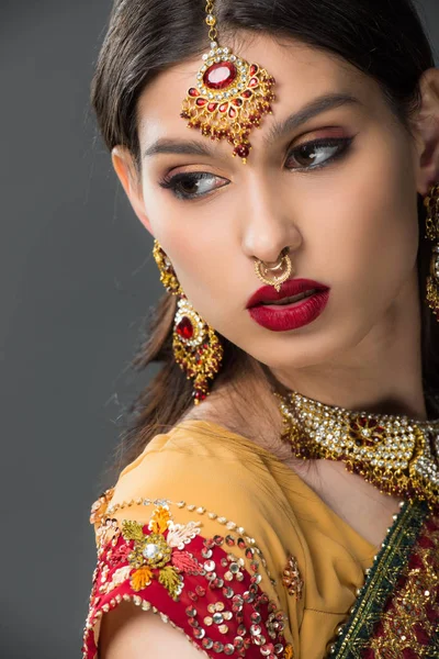 Schöne indische Frau posiert in traditionellem Sari und Bindi, isoliert auf grau — Stockfoto