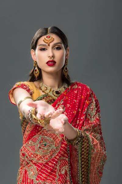 Elegante mulher gesticulando em sari indiano tradicional e acessórios, isolado em cinza — Fotografia de Stock