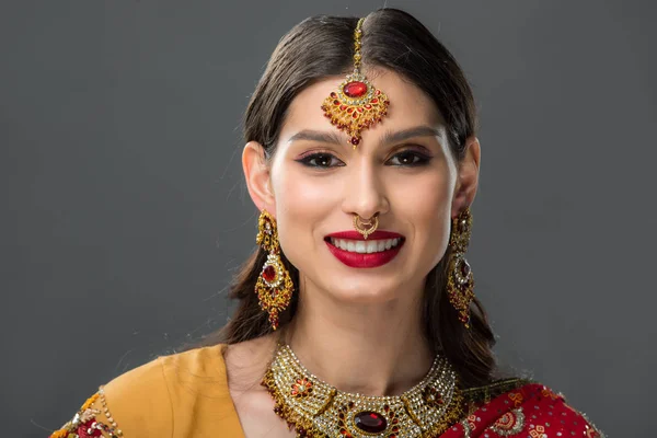 Mulher indiana feliz posando em sari tradicional e acessórios, isolado em cinza — Fotografia de Stock