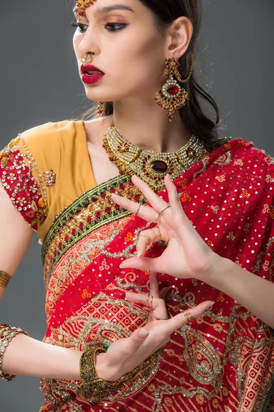 Indian woman in traditional sari gesturing isolated on grey — Stock Photo