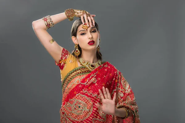 Indian woman gesturing in sari and accessories, isolated on grey — Stock Photo