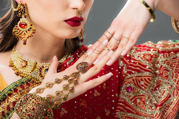 Vista ritagliata di attraente donna indiana gesticolando in accessori tradizionali, isolato su grigio — Foto stock