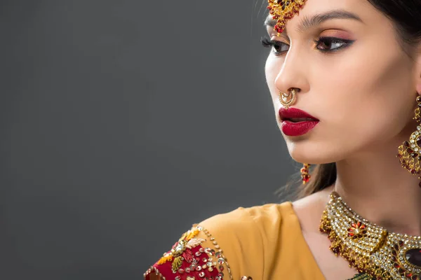 Attraktive Indianerin in traditionellem Sari und Accessoires, isoliert auf grau — Stockfoto