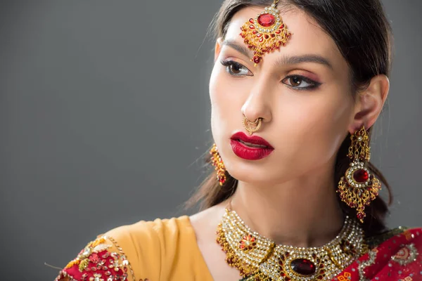 Attractive indian woman in sari and bindi, isolated on grey — Stock Photo