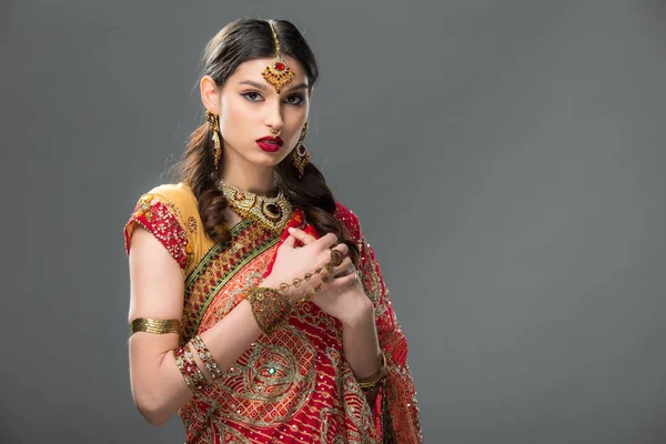 Mujer india elegante en sari y accesorios, aislado en gris - foto de stock