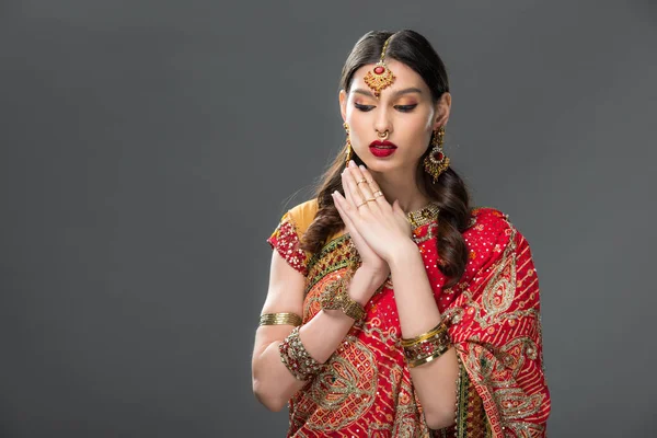 Attractive indian woman in sari and accessories gesturing, isolated on grey — Stock Photo