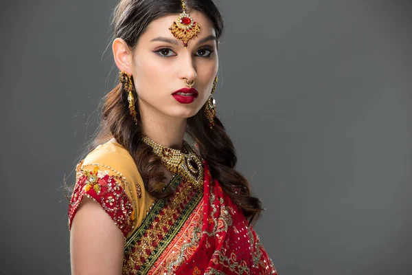 Beautiful indian woman in sari and accessories, isolated on grey — Stock Photo