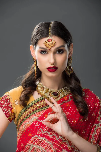 Indian woman in sari and accessories showing gyan mudra, isolated on grey — Stock Photo